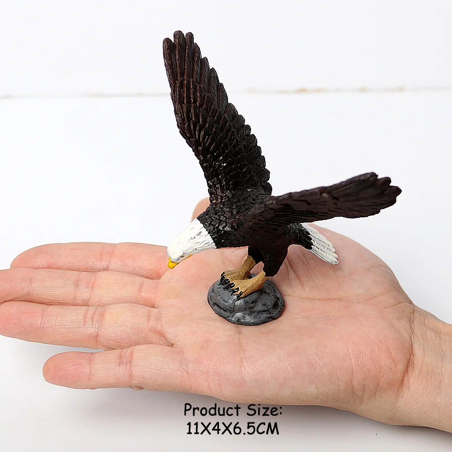 A realistic figurine set of an owl, vulture, and bald eagle perched on a stone, held in a person's hand.