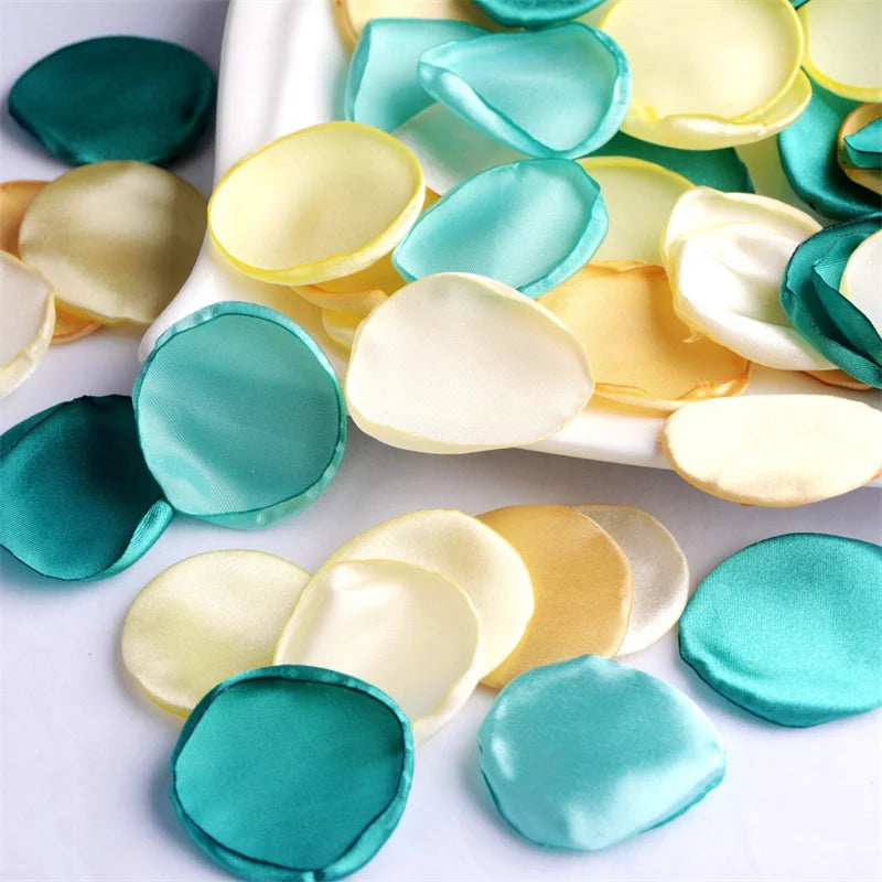 A collection of silk rose petals in various shades of green and yellow arranged on a white platter.
