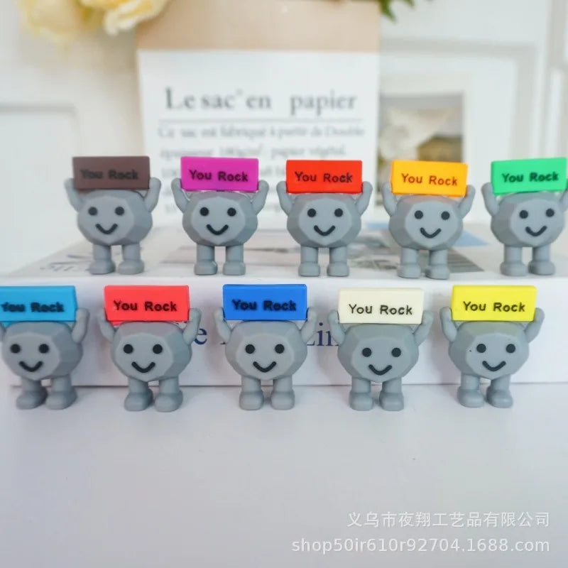 A collection of gray motivational stones with various positive messages like You Rock arranged in rows.