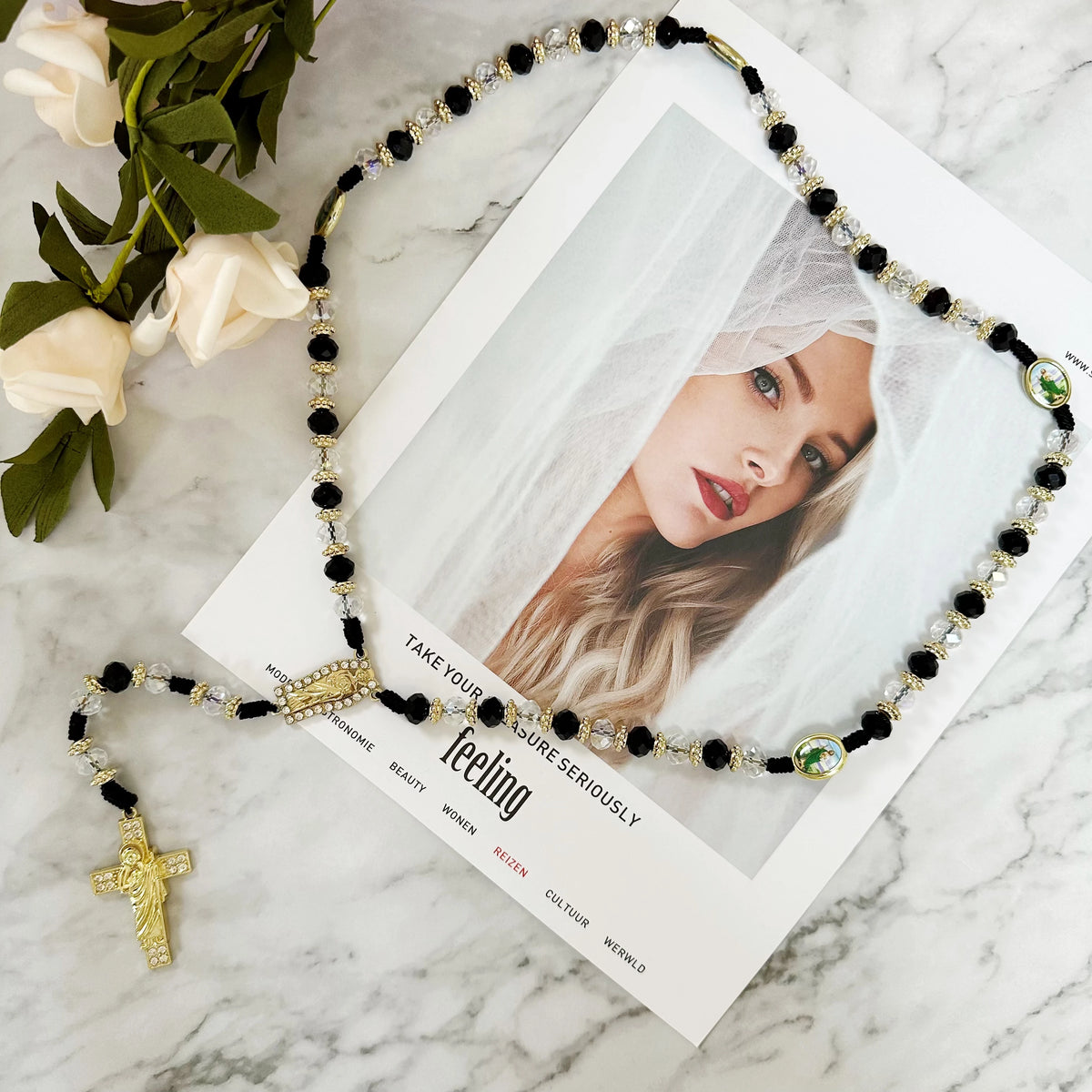 A green crystal rosary necklace featuring Saint Jude and Virgin Mary cross pendants displayed on a white card.
