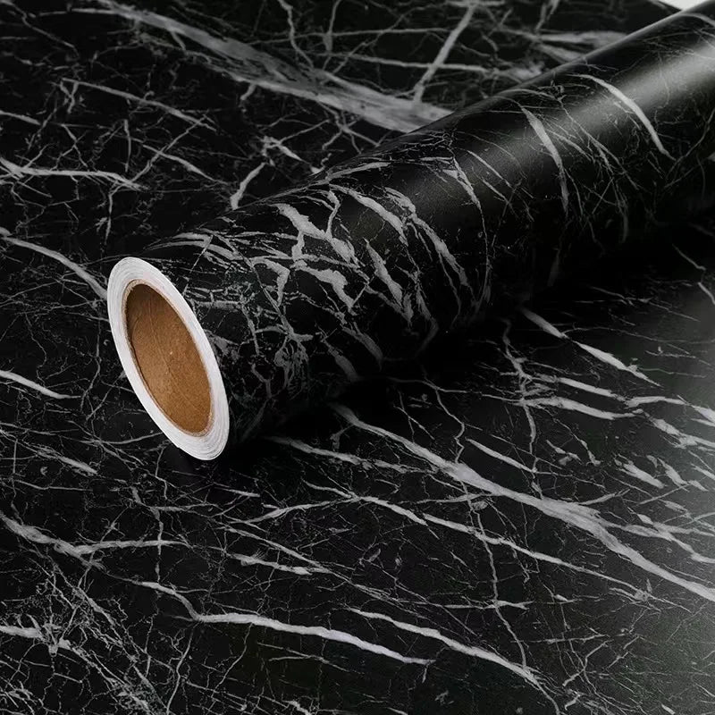 Roll of matte marble self-adhesive waterproof wallpaper with white core on a dark marbled surface