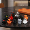A collection of twelve mini resin Halloween duck figurines in various colors and designs displayed on a dark table.