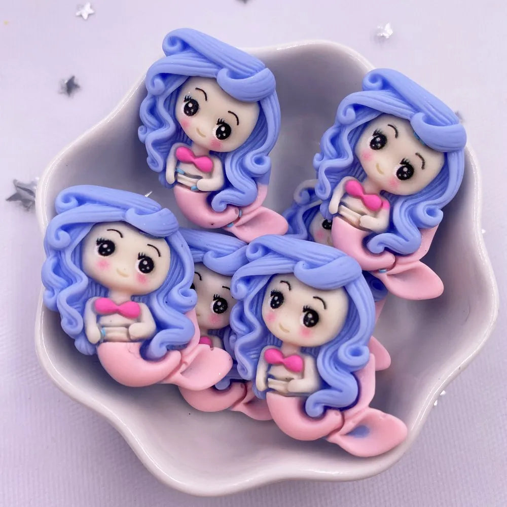 A set of five pastel blue and pink resin figurines depicting mermaid princesses with wavy hair.