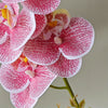 Close-up of vibrant pink and white artificial orchid flowers with intricate spotting
