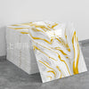 Stack of faux marble self-adhesive wall tiles featuring white and gold swirling patterns.