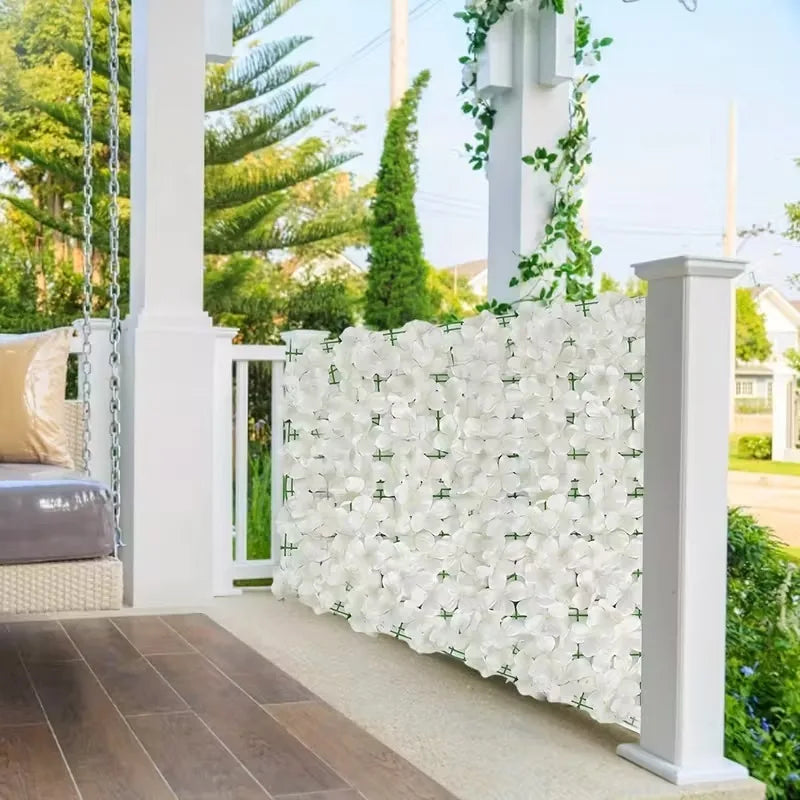 A white artificial cherry blossom privacy fence screen with green foliage and white columns.