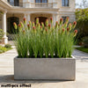 A rectangular planter filled with artificial grass stems used for home decor