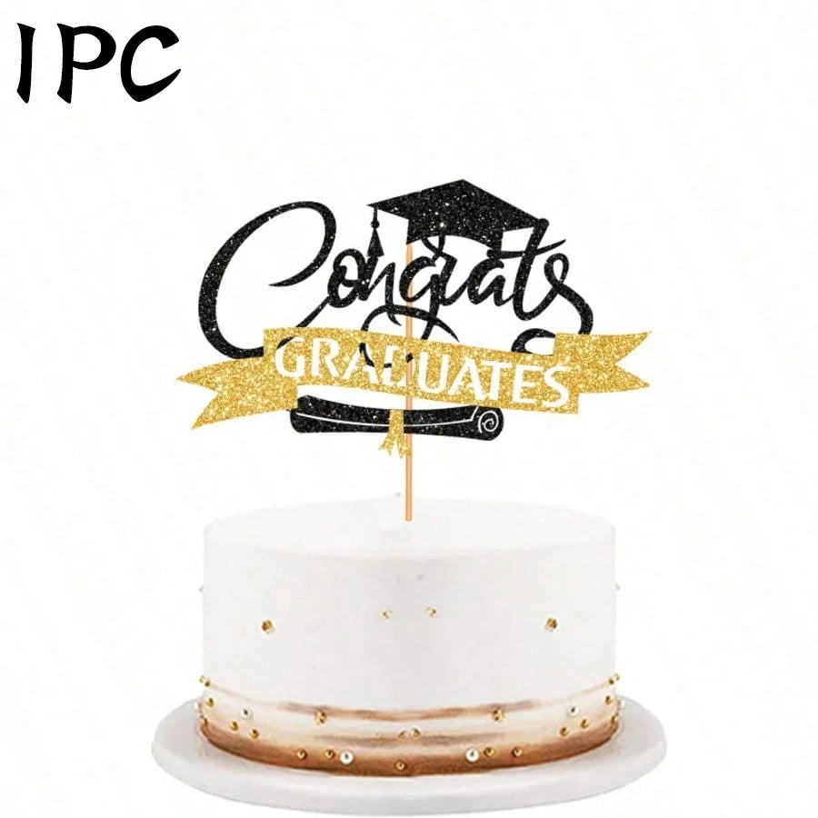 A white cake with gold accents and a black graduation topper featuring the words Congrats Graduates