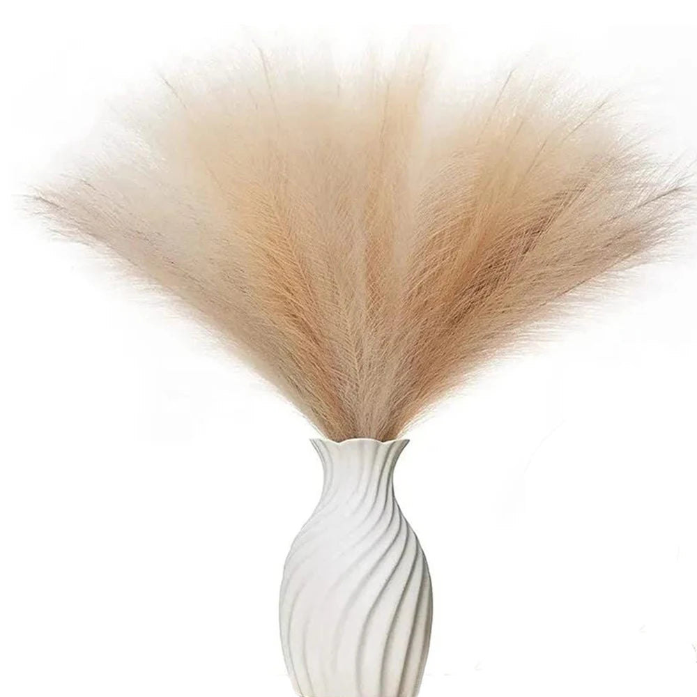 A bundle of dried, light beige pampas grass used as floral decor in a white vase.