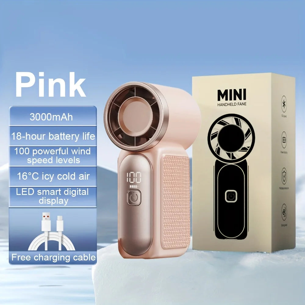 Pink mini handheld fan with a battery and box displayed on a snowy surface
