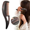 A hand is using a black anti-dandruff scalp massage comb with anti-static bristles on a person's hair.