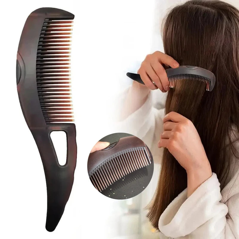 A hand is using a black anti-dandruff scalp massage comb with anti-static bristles on a person's hair.