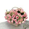 A bouquet of pink and blush artificial roses in a woven basket