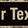 A dark, distressed metal sign with the text Your Text RD on a weathered background.