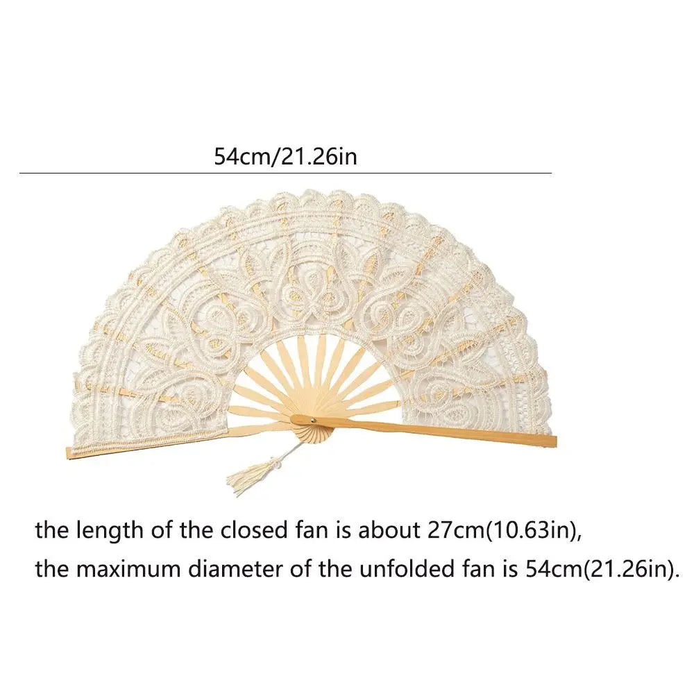 A vintage lace hand fan in cream color with a gold-toned wooden handle and tassel pendant.
