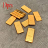 A set of ten simulated gold ingots or fortune charms arranged on a dark gray surface.