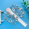 A collection of vintage ship anchor charms and nautical jewelry components laid out on a blue surface.