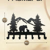 Black industrial iron wall mount key holder featuring seven hooks and a silhouette of a bear and trees