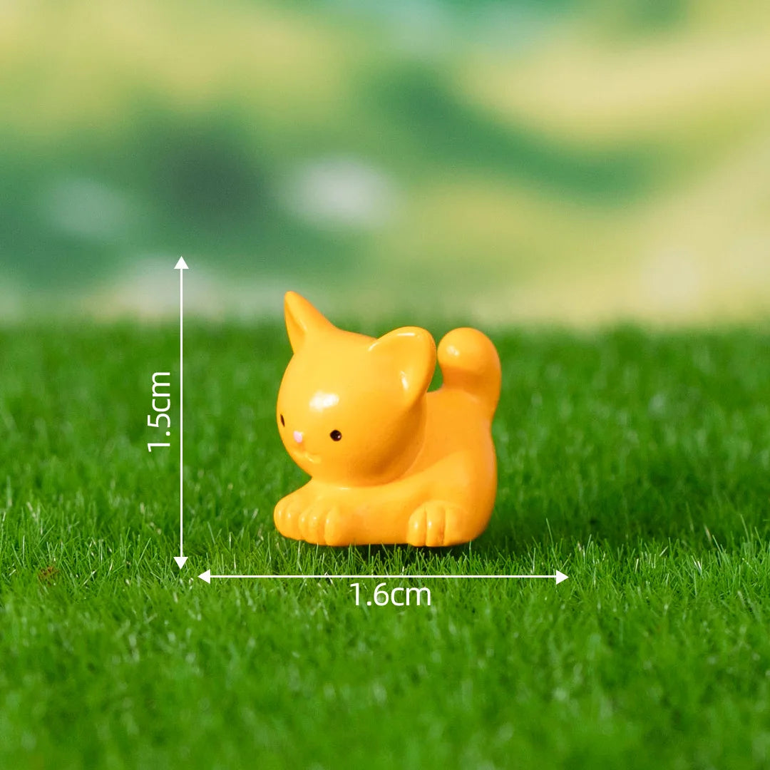 A small yellow cat figurine is placed on green grass with measurement lines indicating its size.