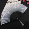 A delicate gray silk folding fan decorated with pink floral patterns, displayed on a dark background.