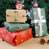 A stack of wrapped gifts in green and red festive Christmas wrapping paper with a Santa decoration.