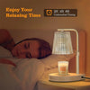 A bedside lamp with a glass shade and a candle on a wooden base, illuminating a woman relaxing in bed.