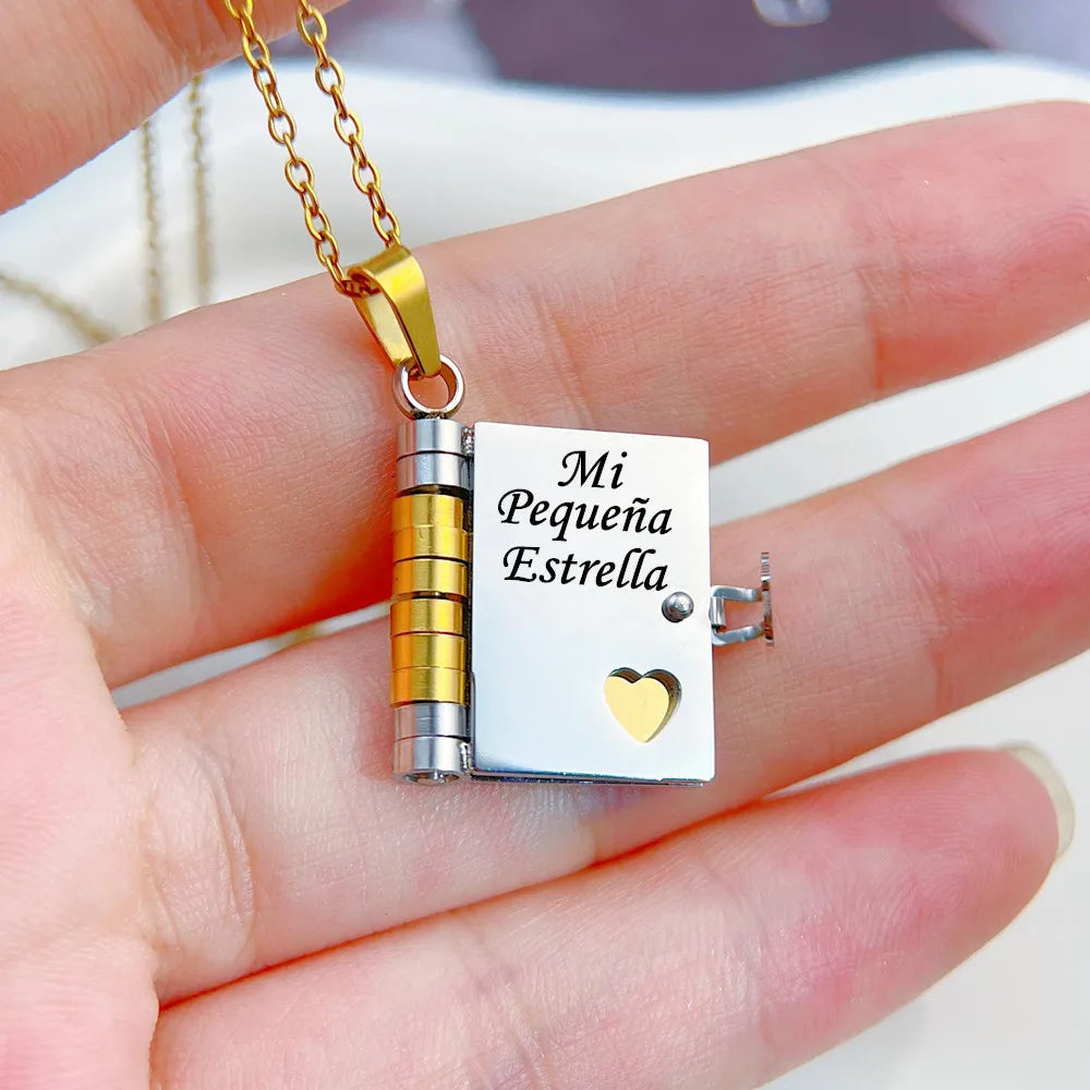 A gold chain necklace features an openable book pendant with the engraved message Mi Pequena Estrella on a silver background.