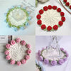 Hand-crocheted rose flower coasters in various shades of green, pink, and blue