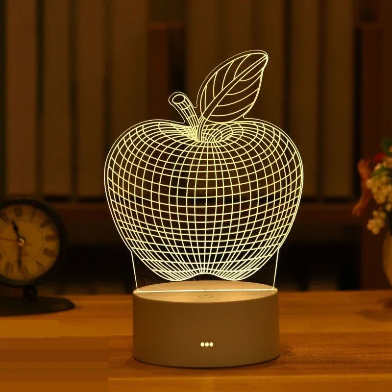 A white wireframe apple night light with a leaf design sits on a wooden surface.