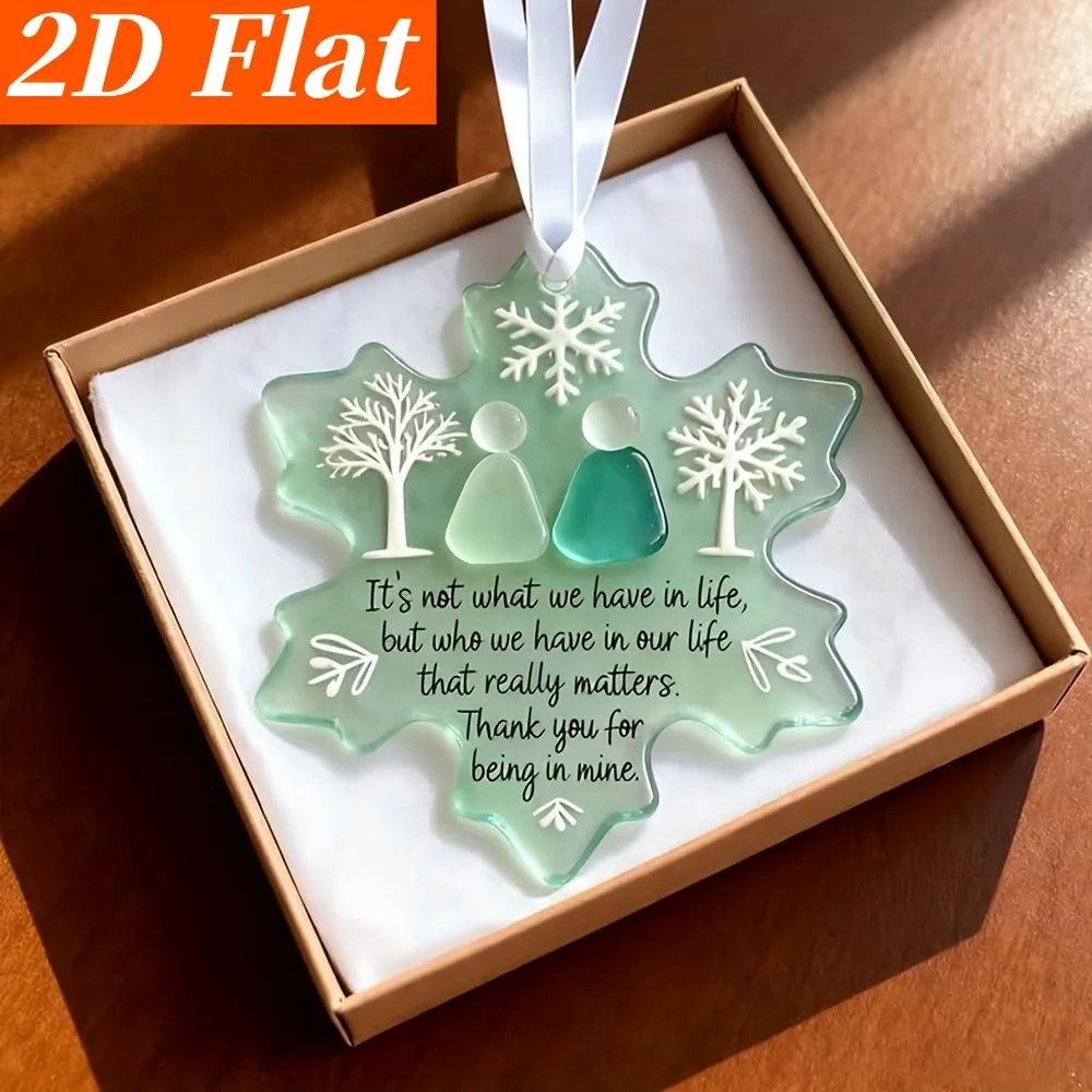 A box containing three sea glass ornaments shaped like snowflakes and figures, presented as a friendship set.