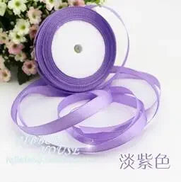 Purple silk satin ribbon spools and rolls on a white background