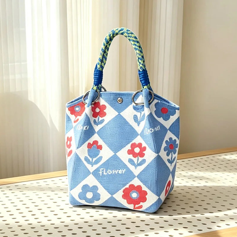 A light blue and white checkered jacquard knitted shoulder bag with a braided handle