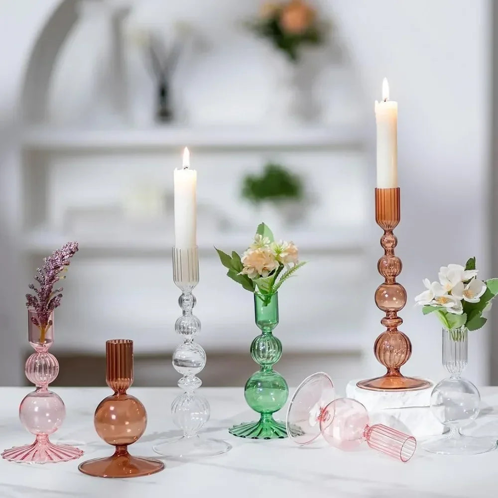 A set of three groovy wavy glass taper candle holders in pink and amber tones displayed on a white surface.