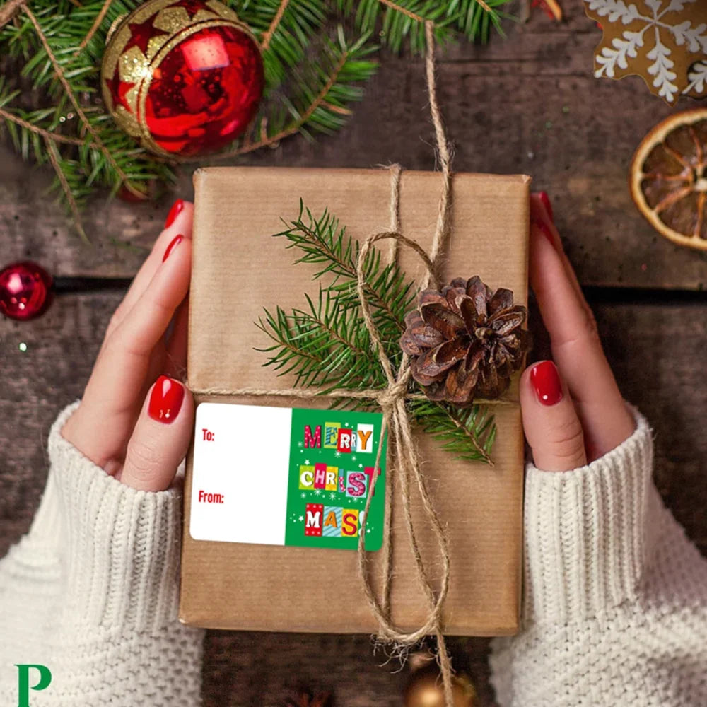 A brown gift box tied with twine and green pine sprigs, featuring Merry Christmas tags.