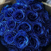 A bouquet of deep blue glitter artificial roses displayed in a dark box.