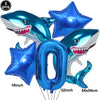 A set of blue shark foil balloons, including a shark shape and the number zero, for an ocean-themed party decoration.