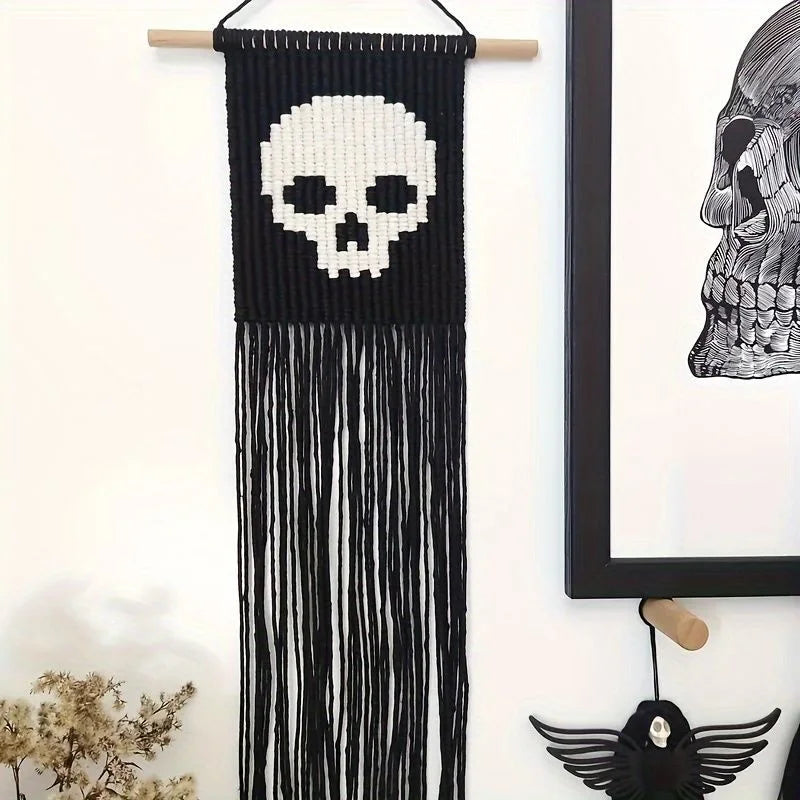 Tapis mural en macramé noir avec un crâne blanc et des franges longues.