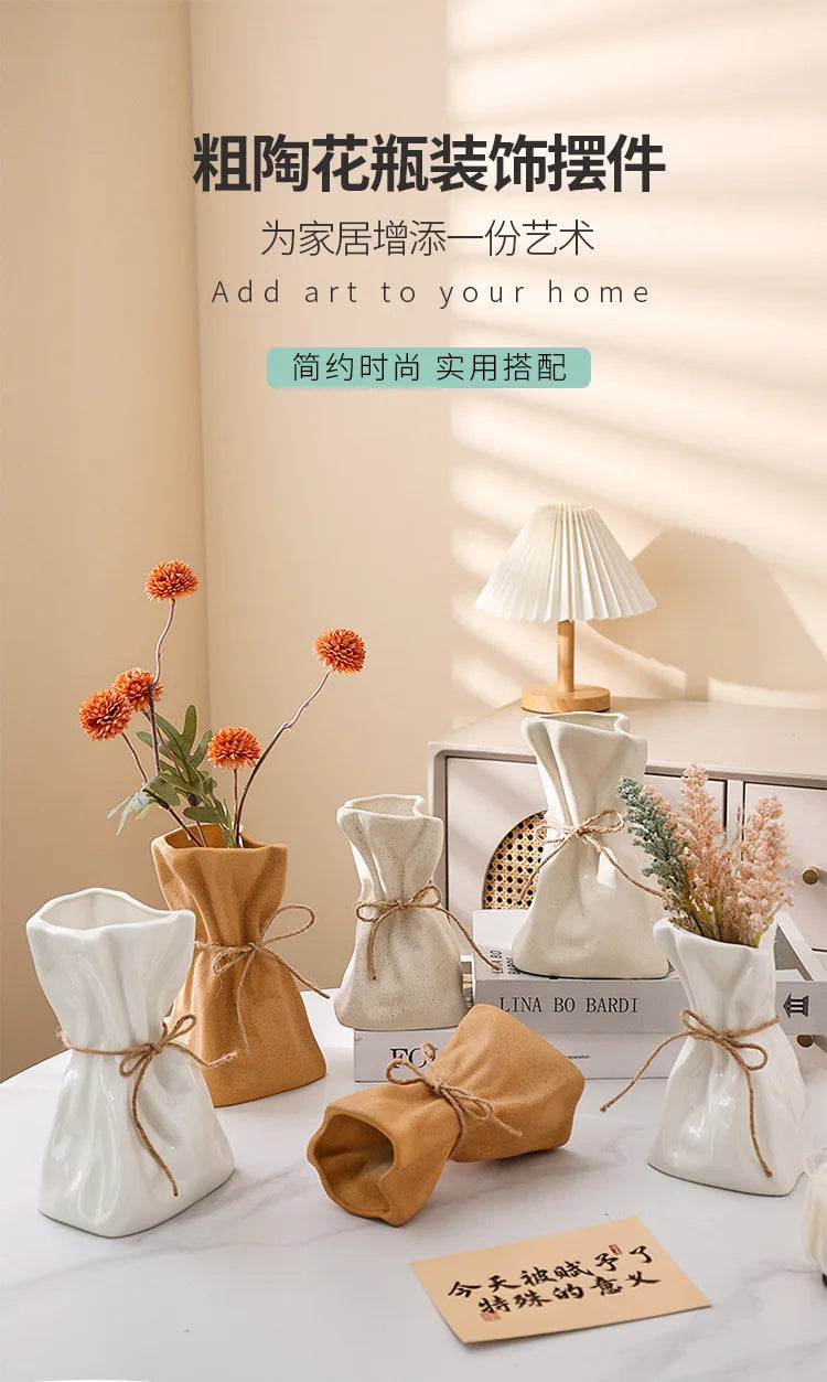 A set of ceramic and glass money bag shaped vases for hydroponic plants displayed on a white table.