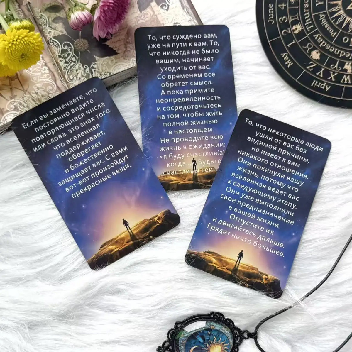 A set of oracle tarot cards with text and imagery resting on white fur.