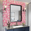 A vanity area featuring a large mirror framed by a pink rose flower wall and a modern countertop sink.
