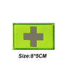 A bright lime green tactical morale patch featuring a silver cross symbol.
