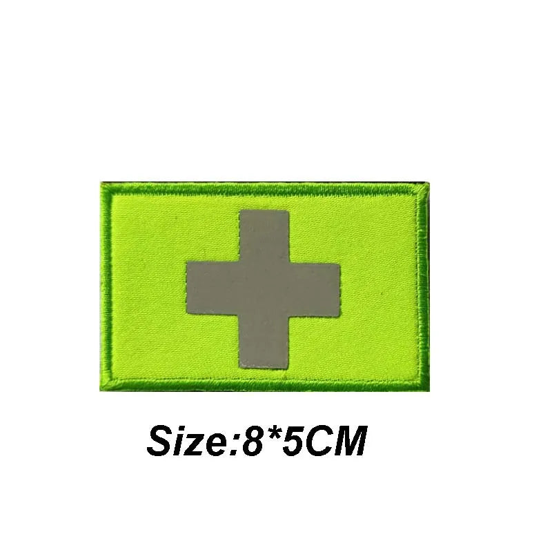 A bright lime green tactical morale patch featuring a silver cross symbol.