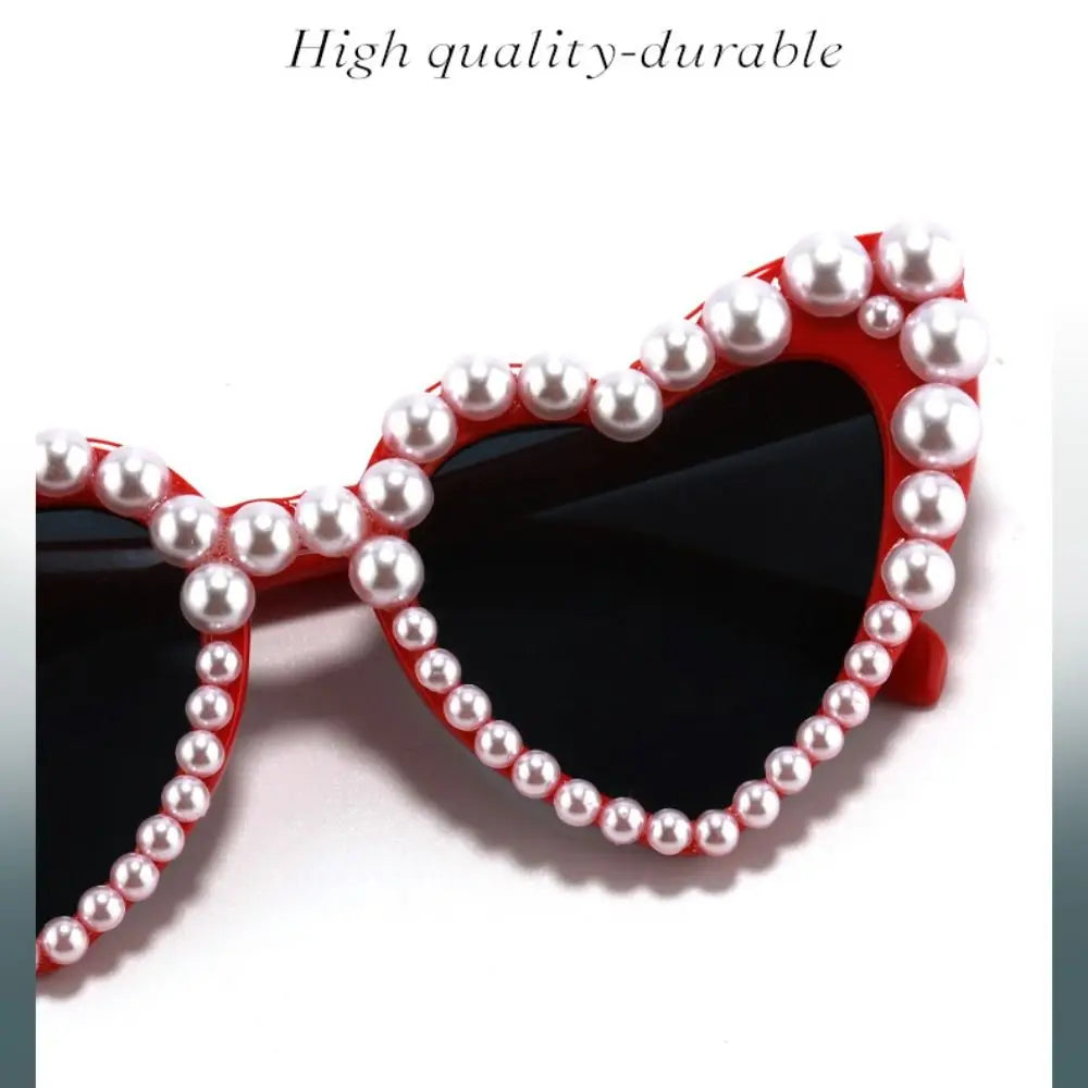 Red heart-shaped sunglasses adorned with white pearls