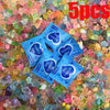 A pile of glow in the dark resin decor pieces, including small, colorful, translucent items.