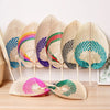 A collection of peach-shaped bamboo woven hand fans displaying various colors and patterns.
