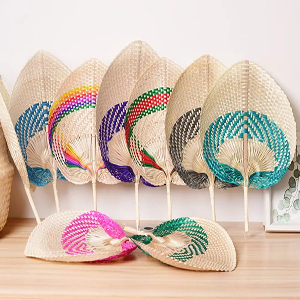A collection of peach-shaped bamboo woven hand fans displaying various colors and patterns.