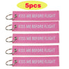 Five pink woven keychains with the text Kiss Me Before Flight