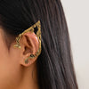 Gold elf flower leaf clip earrings worn on a woman's ear.