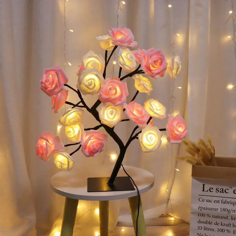 Rosa und gelbe Rosenblüten-Baum-Nachtleuchte mit leuchtenden Blüten auf weißem Tisch.
