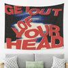 A dark tapestry wall hanging with red text that reads Get Out of Your Head
